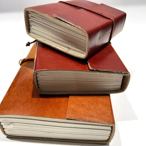 Elegant tan wrap enhancing the style of vintage leather journals, perfect for creative writing and journaling enthusiasts.