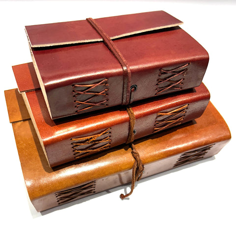 Elegant tan wrap enhancing the style of vintage leather journals, perfect for creative writing and journaling enthusiasts.